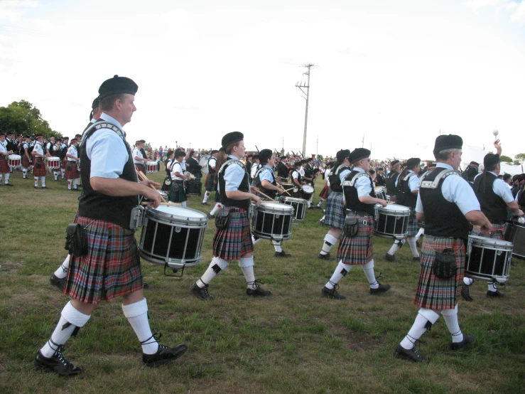 a large group of young men playing music on grass