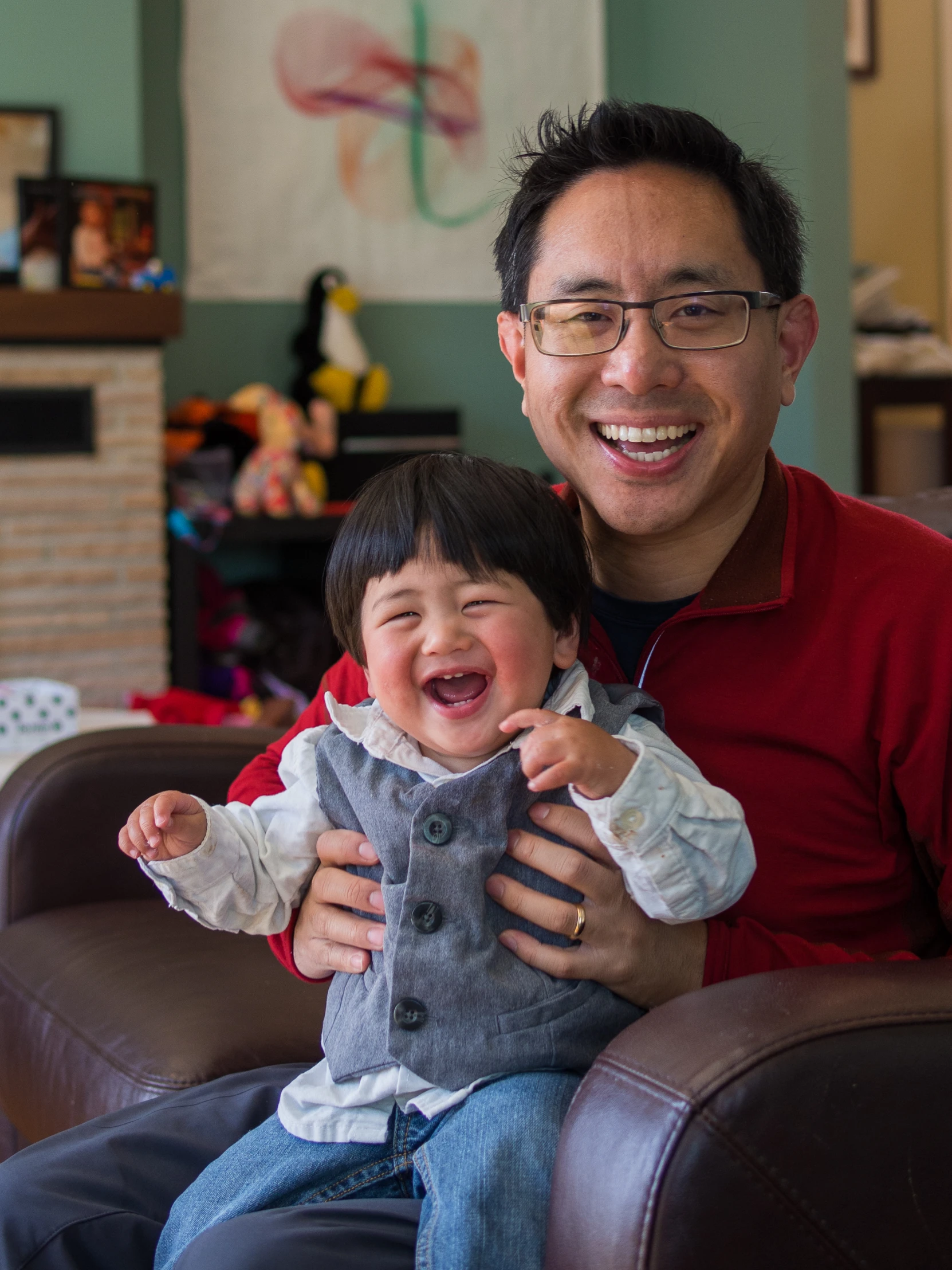 a man is sitting in a chair holding a boy