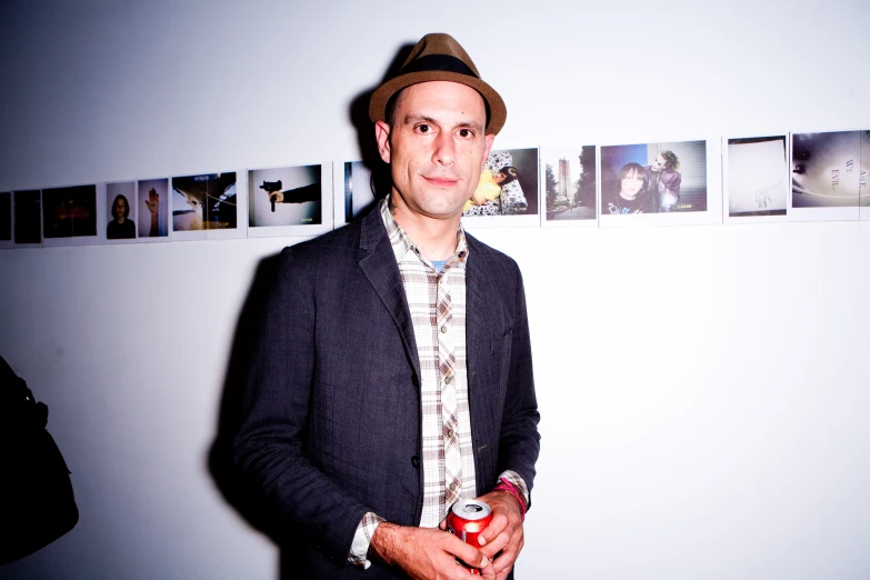 a man wearing a fedora poses for a po