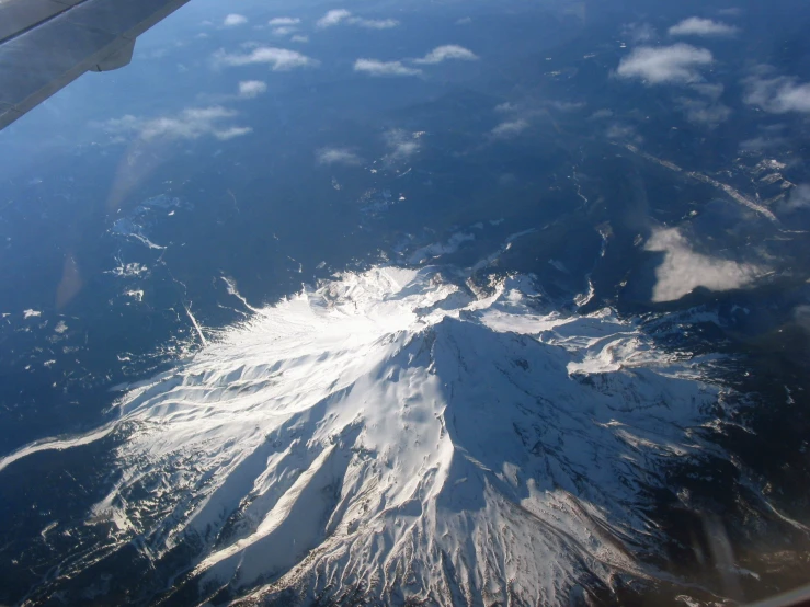 snow capped mountains from the air flying over it