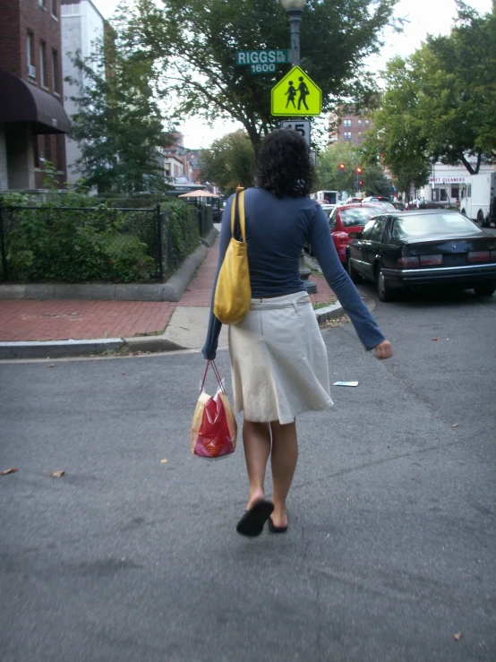 a woman walks down the street while carrying bags