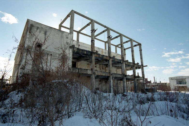 an industrial building that is being constructed on top of a snowy hill