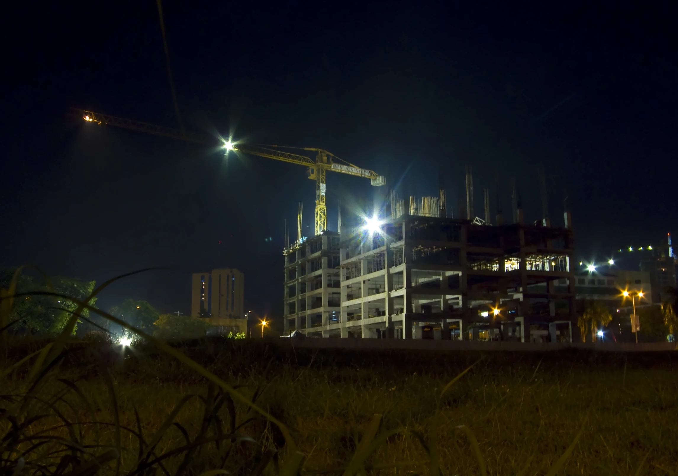 a building under construction is lit by street lamps