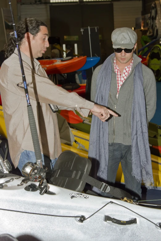 two men are near a car with fishing gear