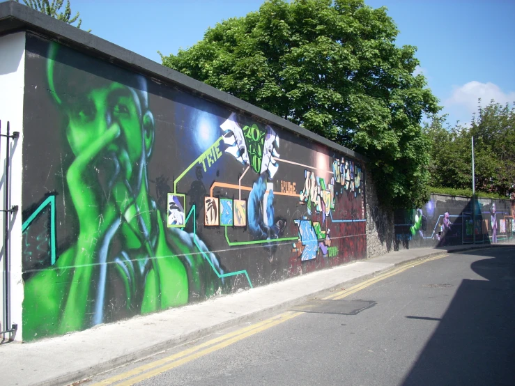 a colorful wall is next to a road