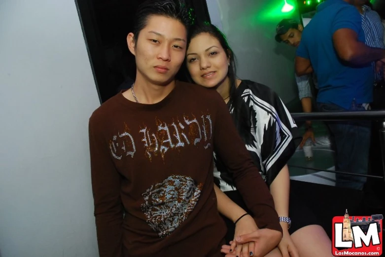 a young man poses for a picture with a woman in front of him