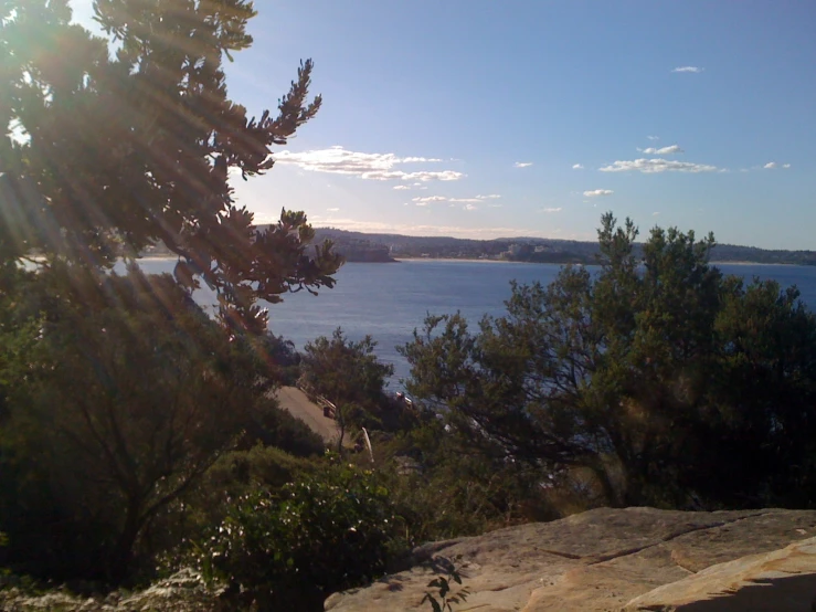 the view from the cliff over a lake surrounded by trees