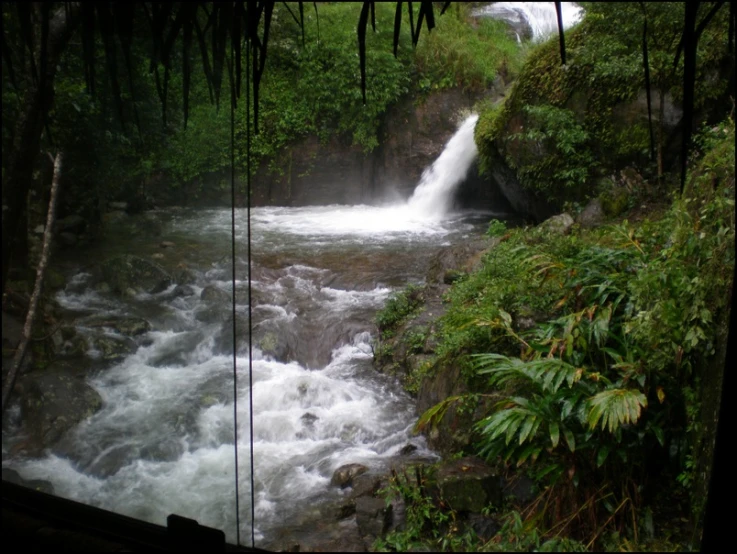 a waterfall in the distance as seen through some glass