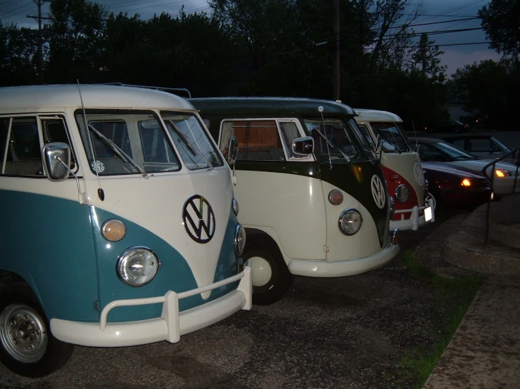 three classic vw buses are parked next to each other