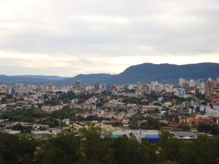 a view of an urban city, mountains in the background