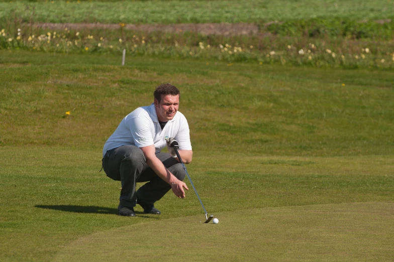 a man kneeling down with a golf club in hand