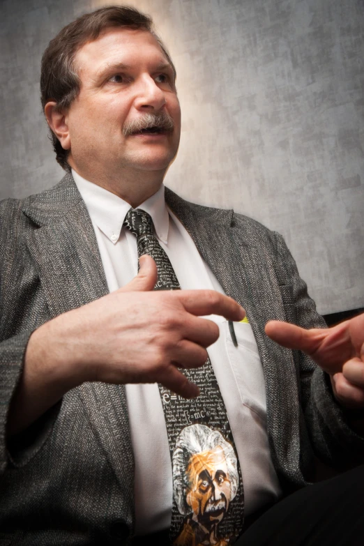 a man in suit and tie with his hands out