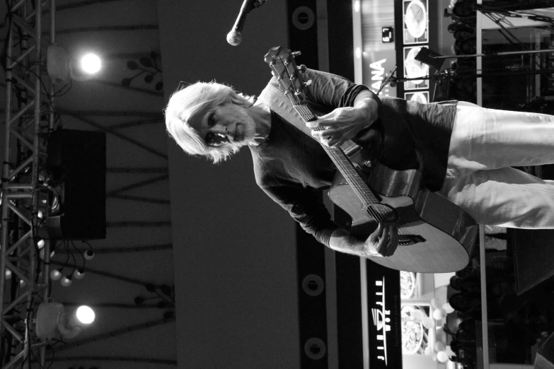 woman playing a song on a stage with an instrument