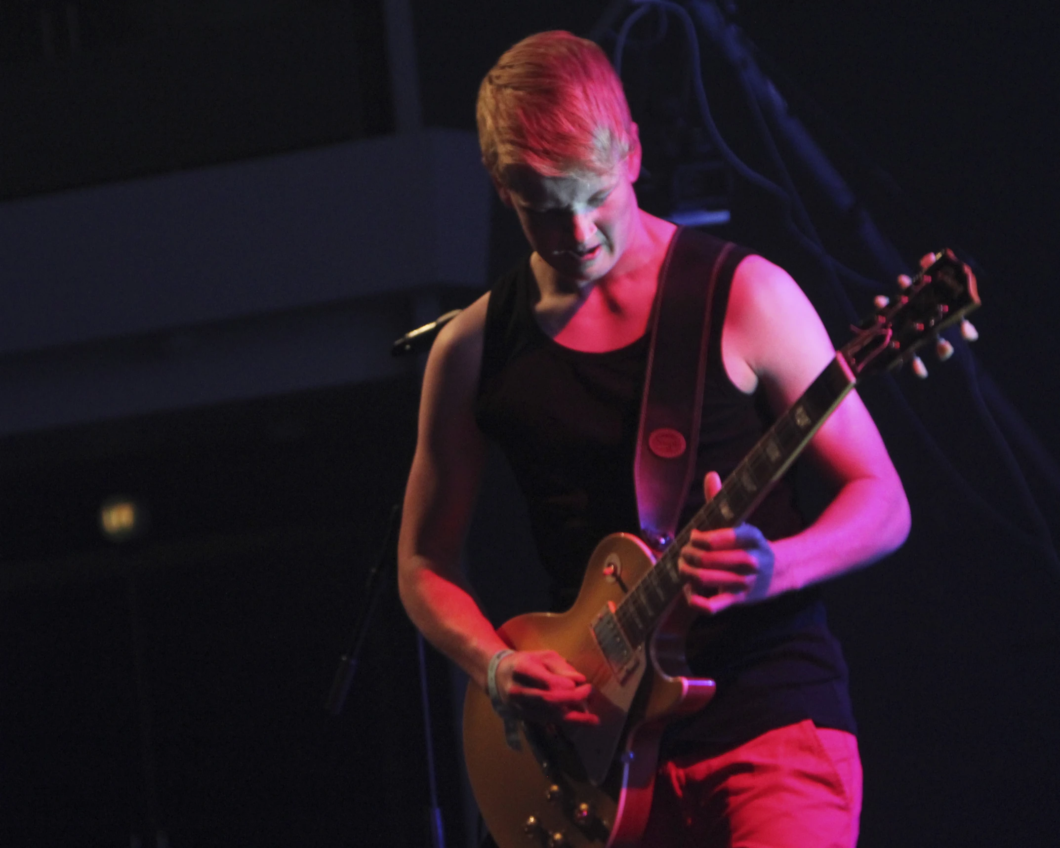 young man playing a guitar with red light