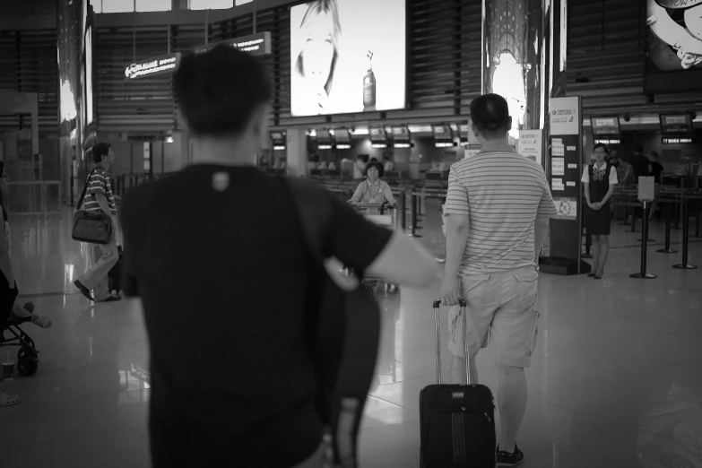 a boy walking through an airport with a luggage bag