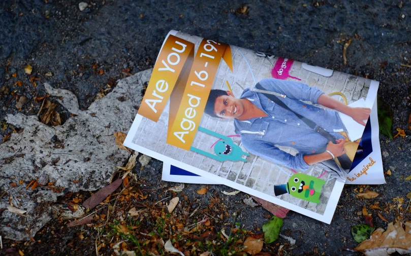 a newspaper laying on the ground next to an object
