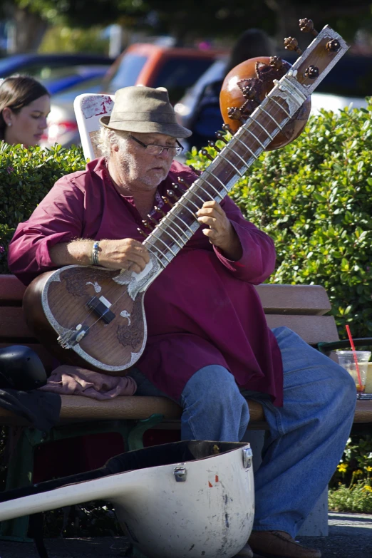 an old man with a musical instrument in his lap