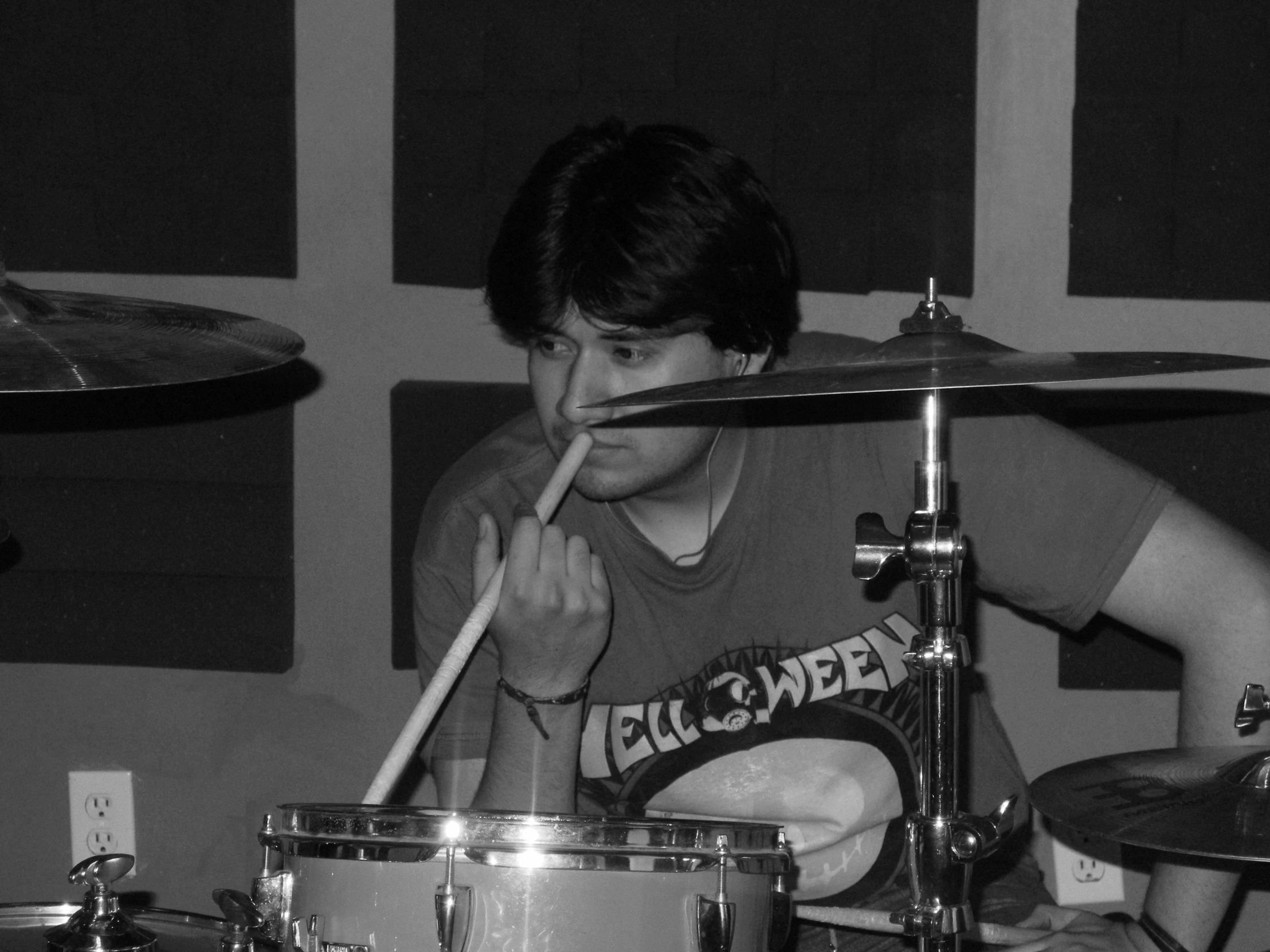 a young man with dark hair playing drums