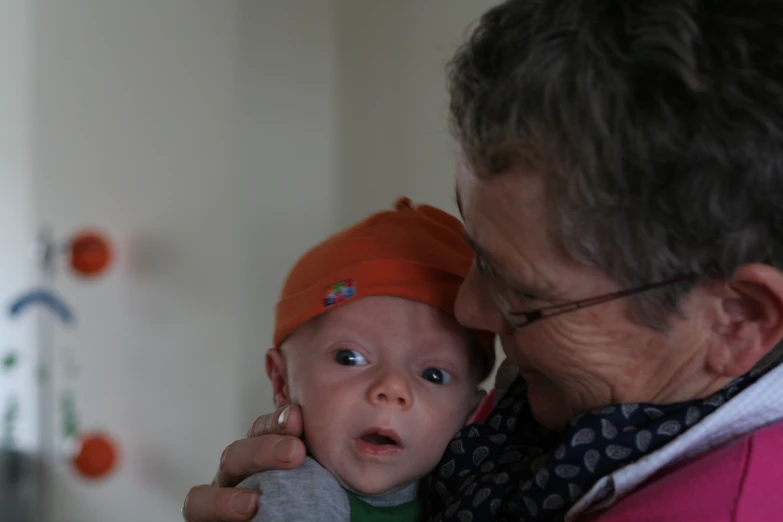 a man is hugging a baby with one eye open