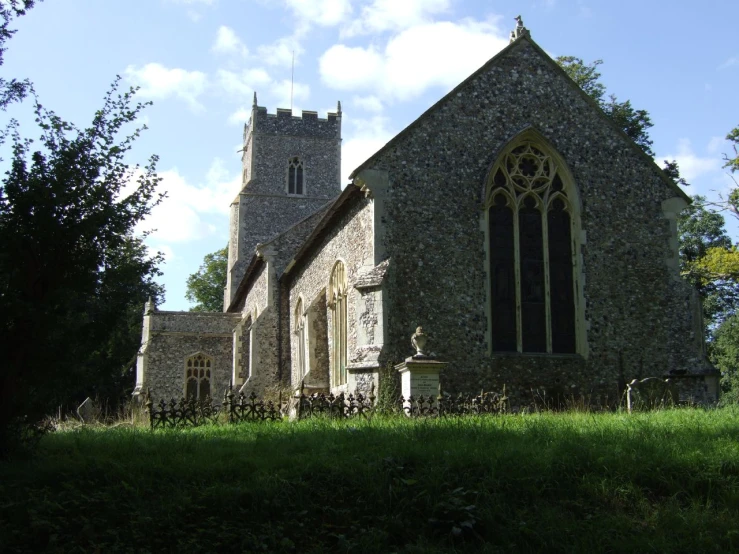 an old church sits in a grassy field