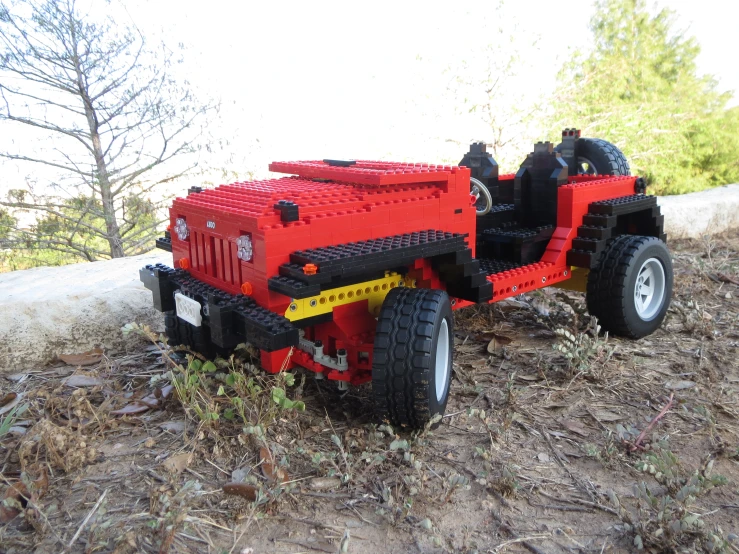 a red and black truck with a big wheel