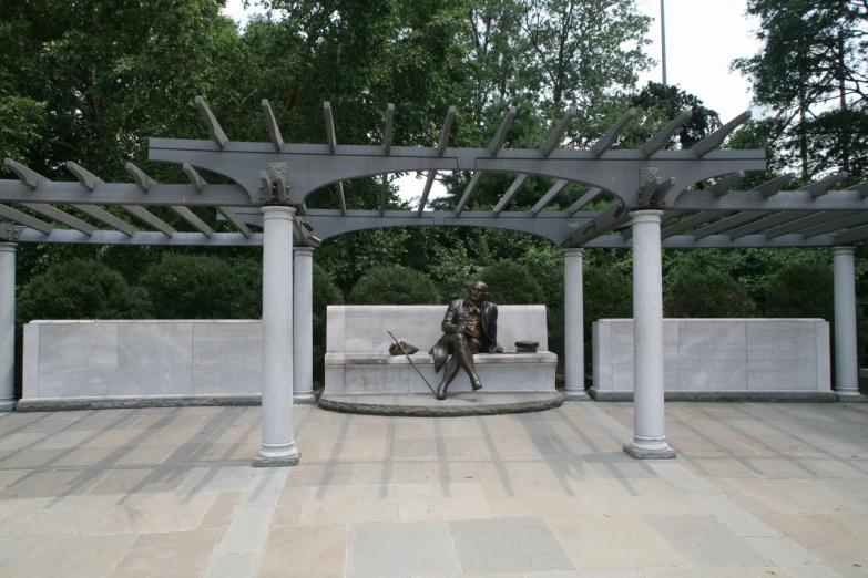 a statue sitting on a bench in a park