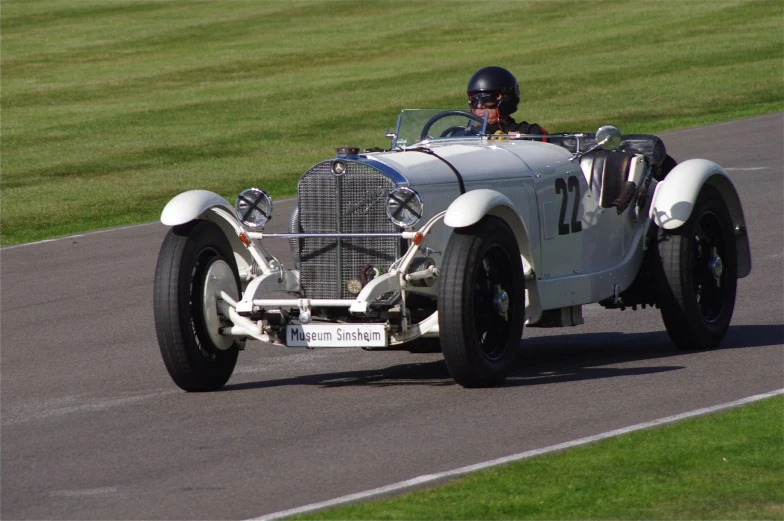 a white car drives down a paved course