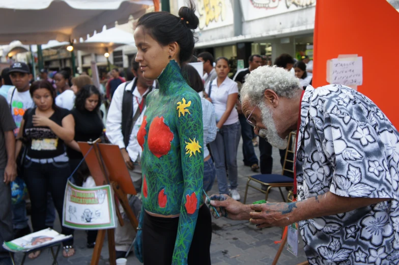 a man and woman painted with various colors near the street