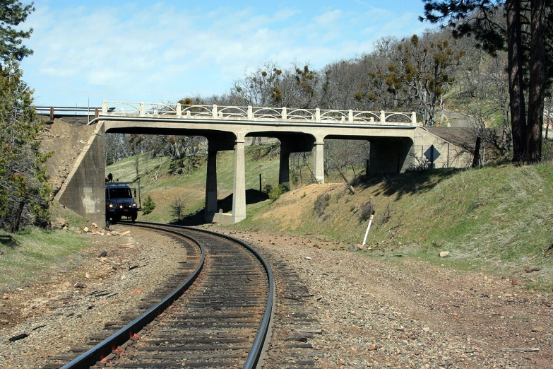 a large truck traveling underneath an overpass on a train track