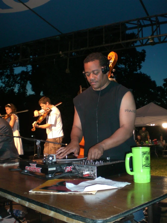 man with headphones at table at outdoor music event