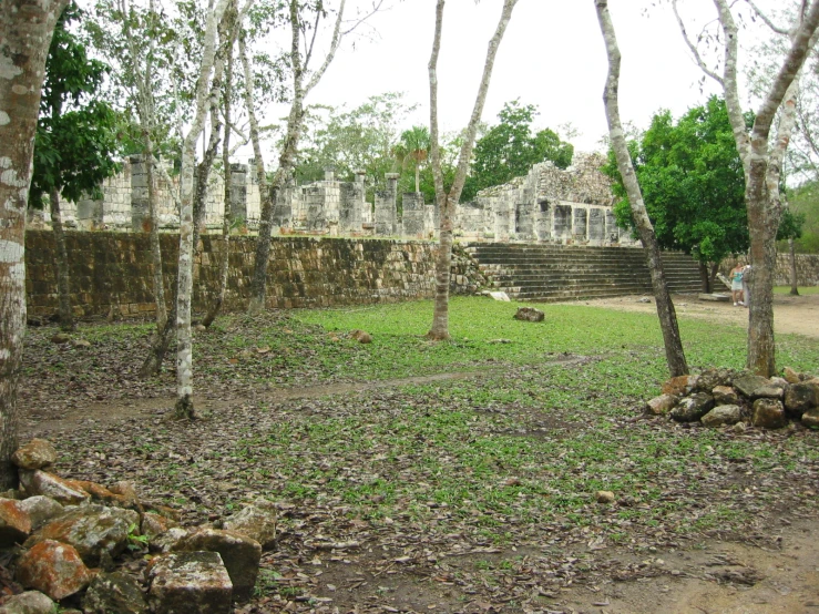 an old stone structure in the woods by some trees