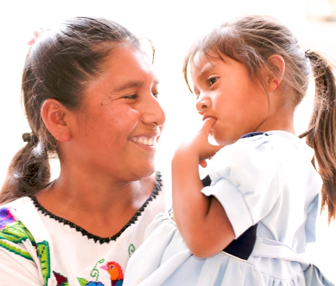 a girl standing next to an older woman