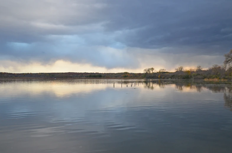 a lake with water and dark clouds surrounding it