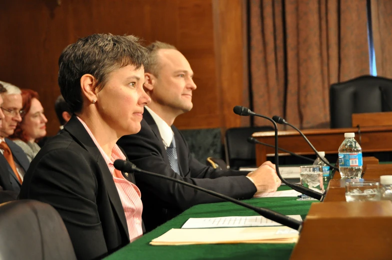 three people sitting at tables during a seminar