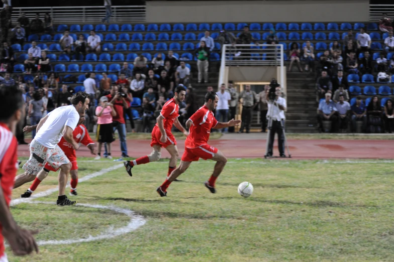 a group of men playing soccer in front of an audience