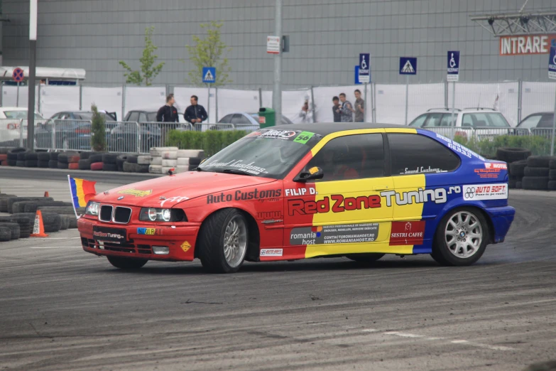 a bmw racing car on the track with fans watching