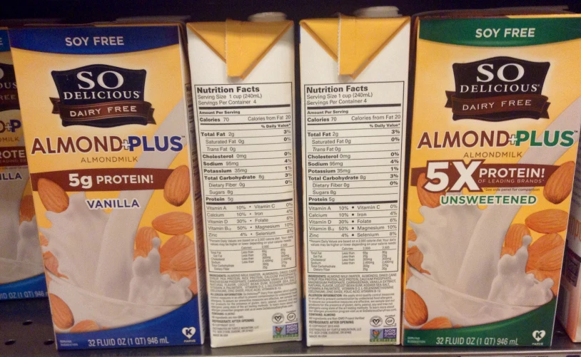 boxes of almo plus and so delicious drink are lined up on a shelf