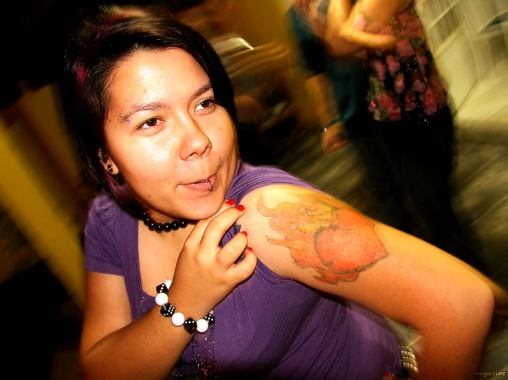 young lady getting tattooed with colorful designs on arm