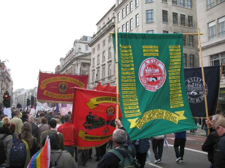 many people holding banners and carrying flags on a city street