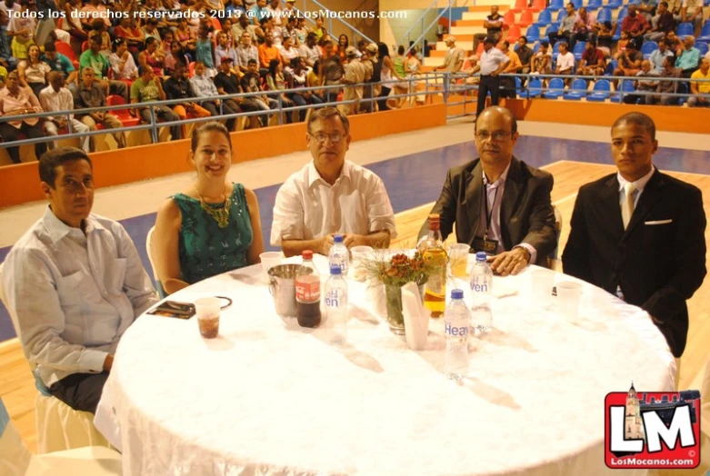 a group of people sitting around a round white table