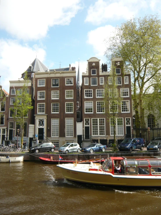 a boat on a river near a bunch of cars and buildings