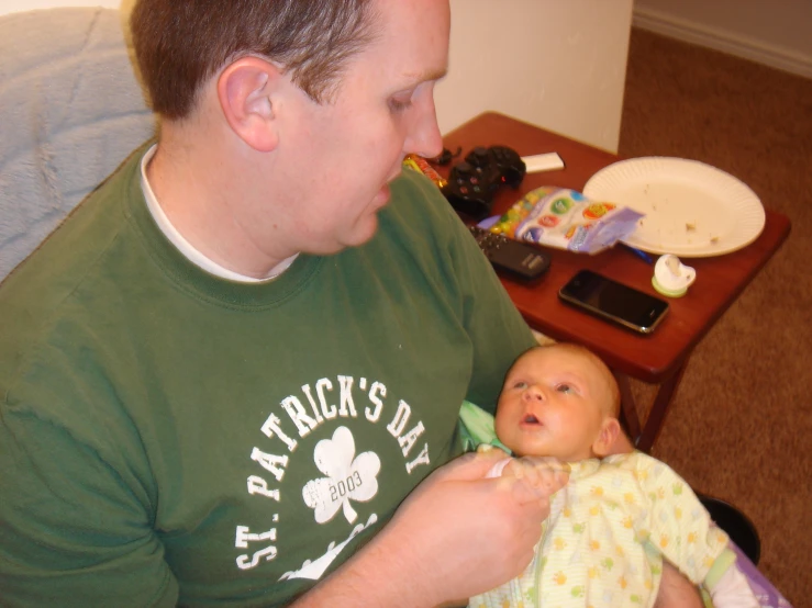 a man holds a baby that is in his lap