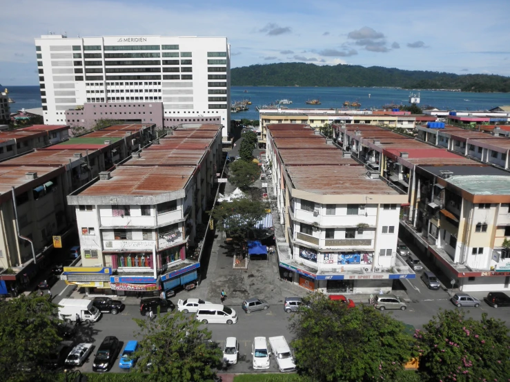 some buildings parked cars and people near a body of water