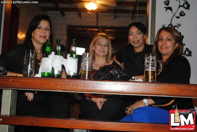three women are sitting at a bar posing for a po
