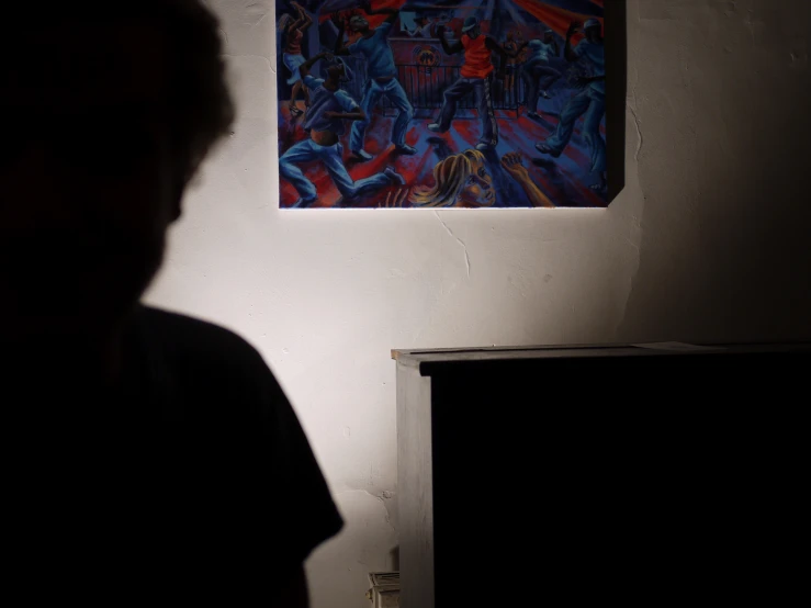 a man staring at a painting on the wall