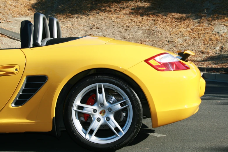 yellow sports car with open top parked in lot