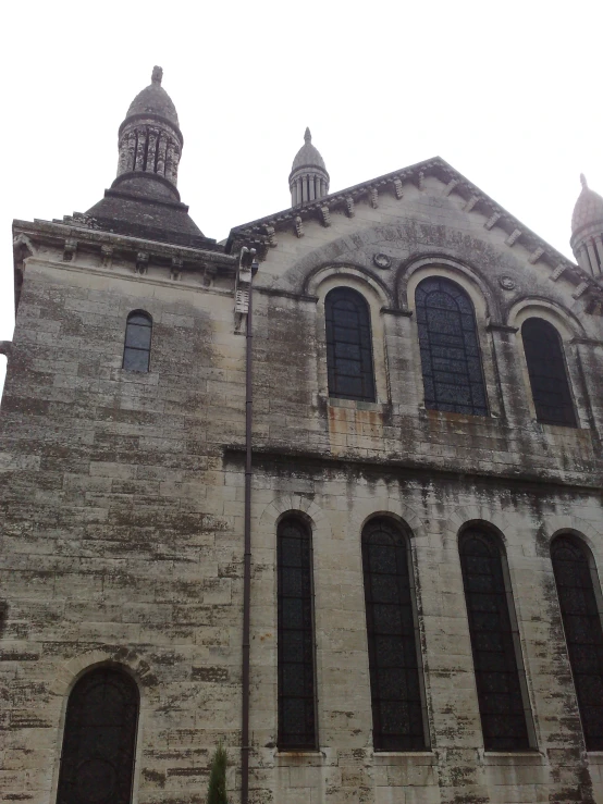 an old stone building with three large windows and two towers