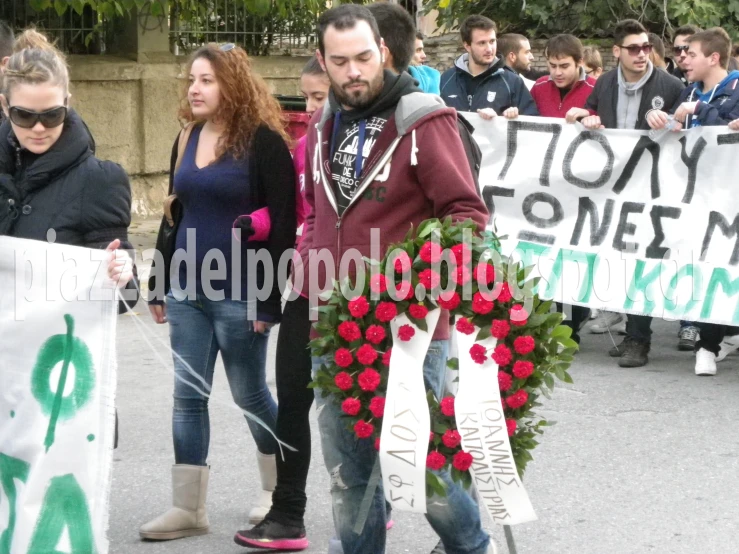 people protesting outside holding flowers and signs that say no