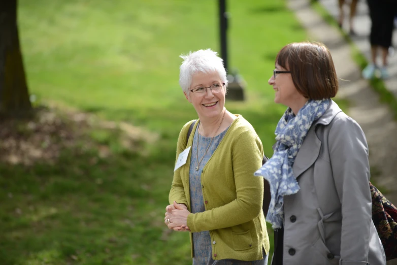 two women standing next to each other talking