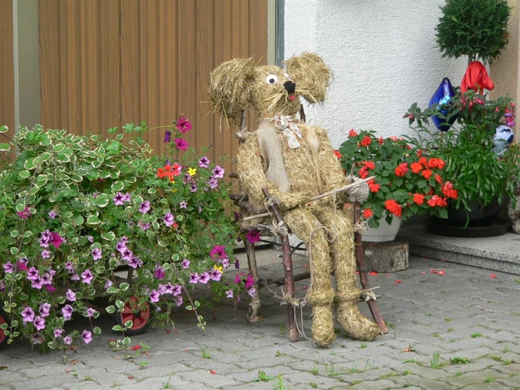a large, brown dog sitting on a chair next to flowers